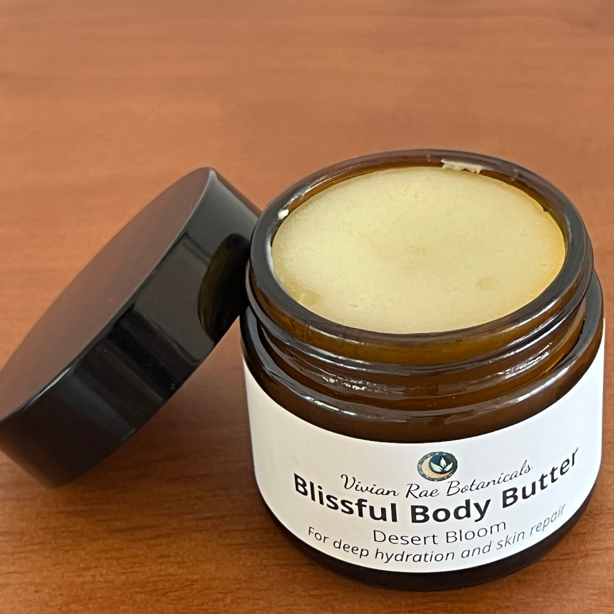 Open jar of Blissful Body Butter, Desert Bloom, with its lid beside it