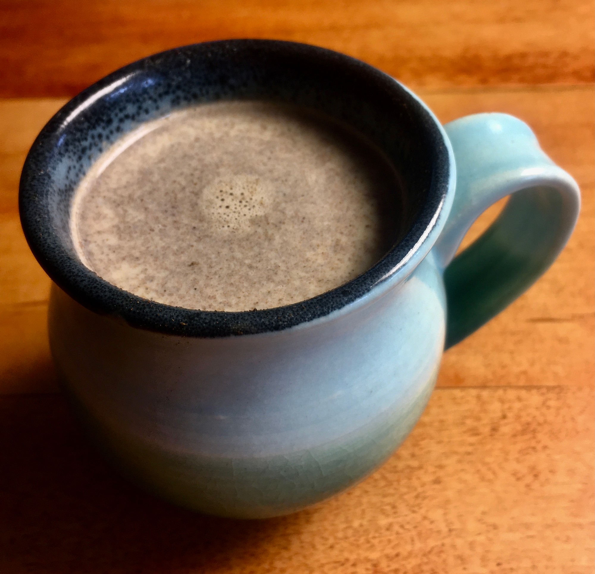 Frothy adaptogen chai in a blue and teal ceramic mug