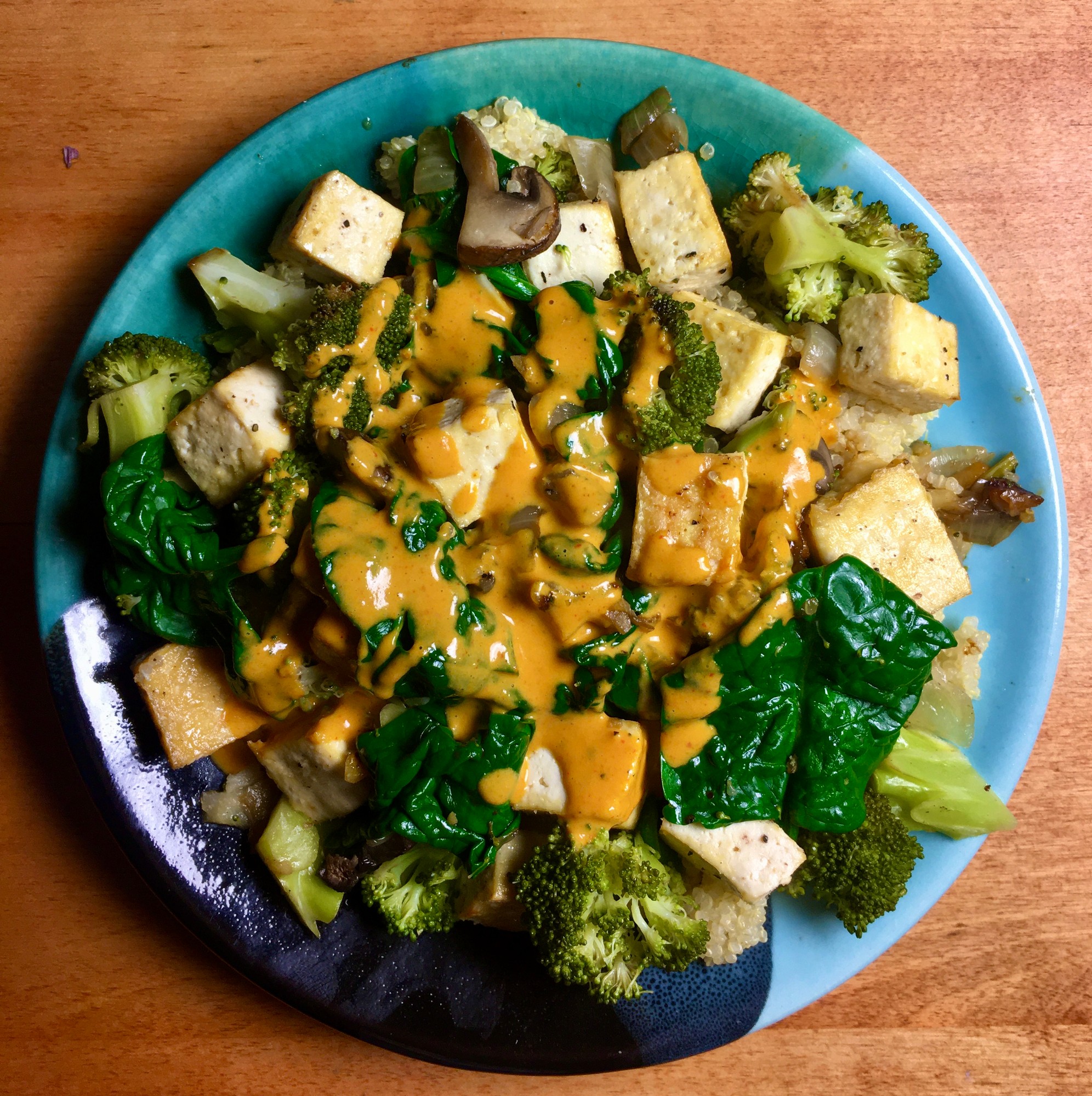 Tofu, broccoli, spinach and mushrooms over quinoa with an orange curry sauce