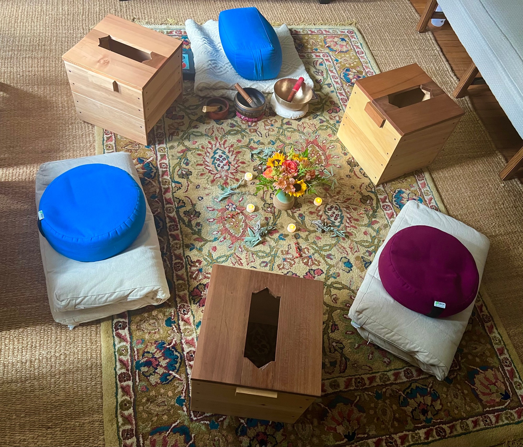 Steam boxes and floor cushions in a circle around sunflowers and candles