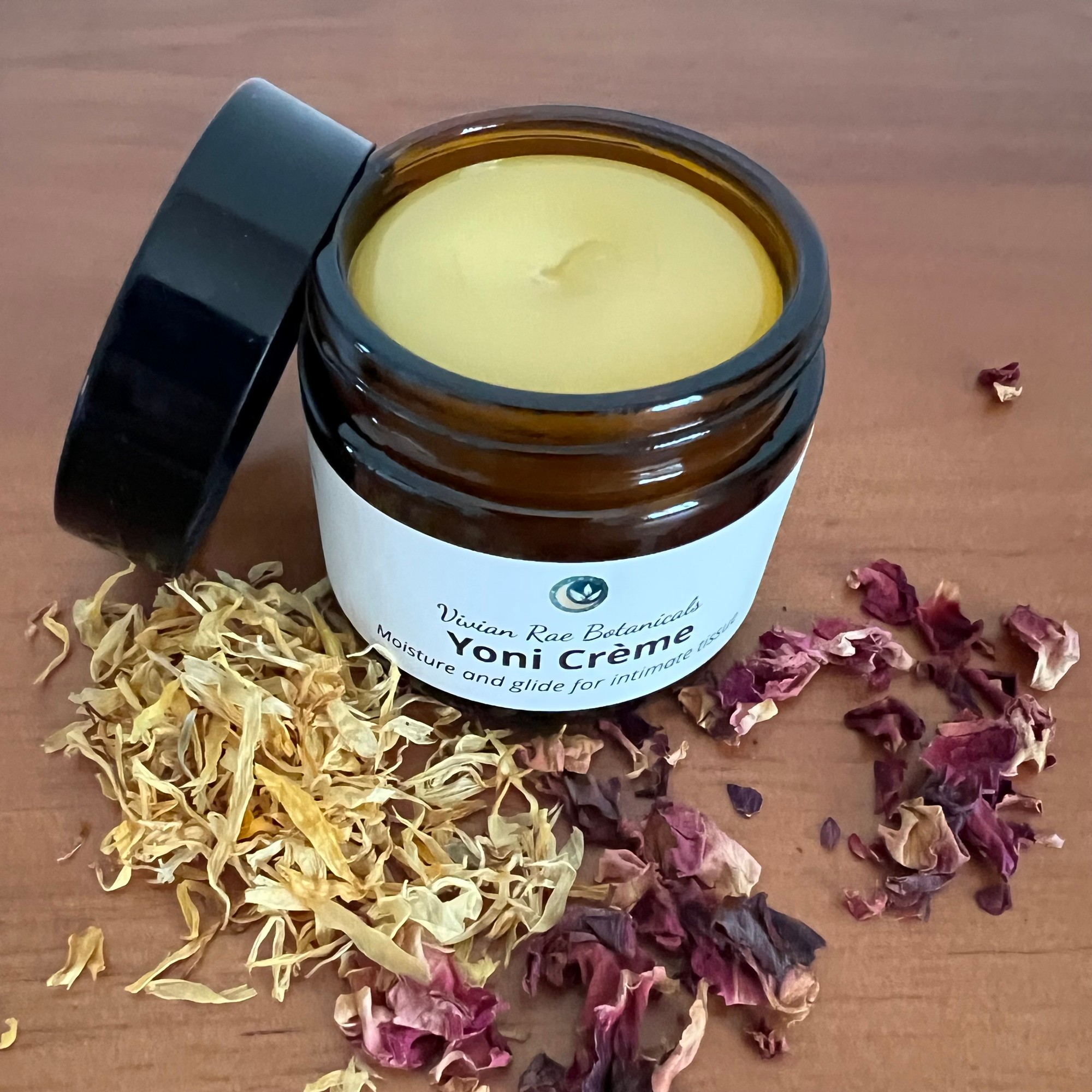 Open jar of Yoni Crème with dried calendula and rose petals